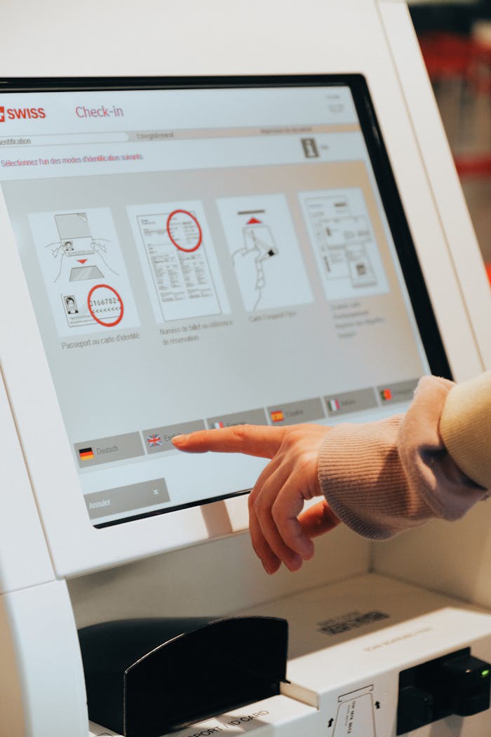 our-journey-03 Hand interacting with airport self-service kiosk for check-in.